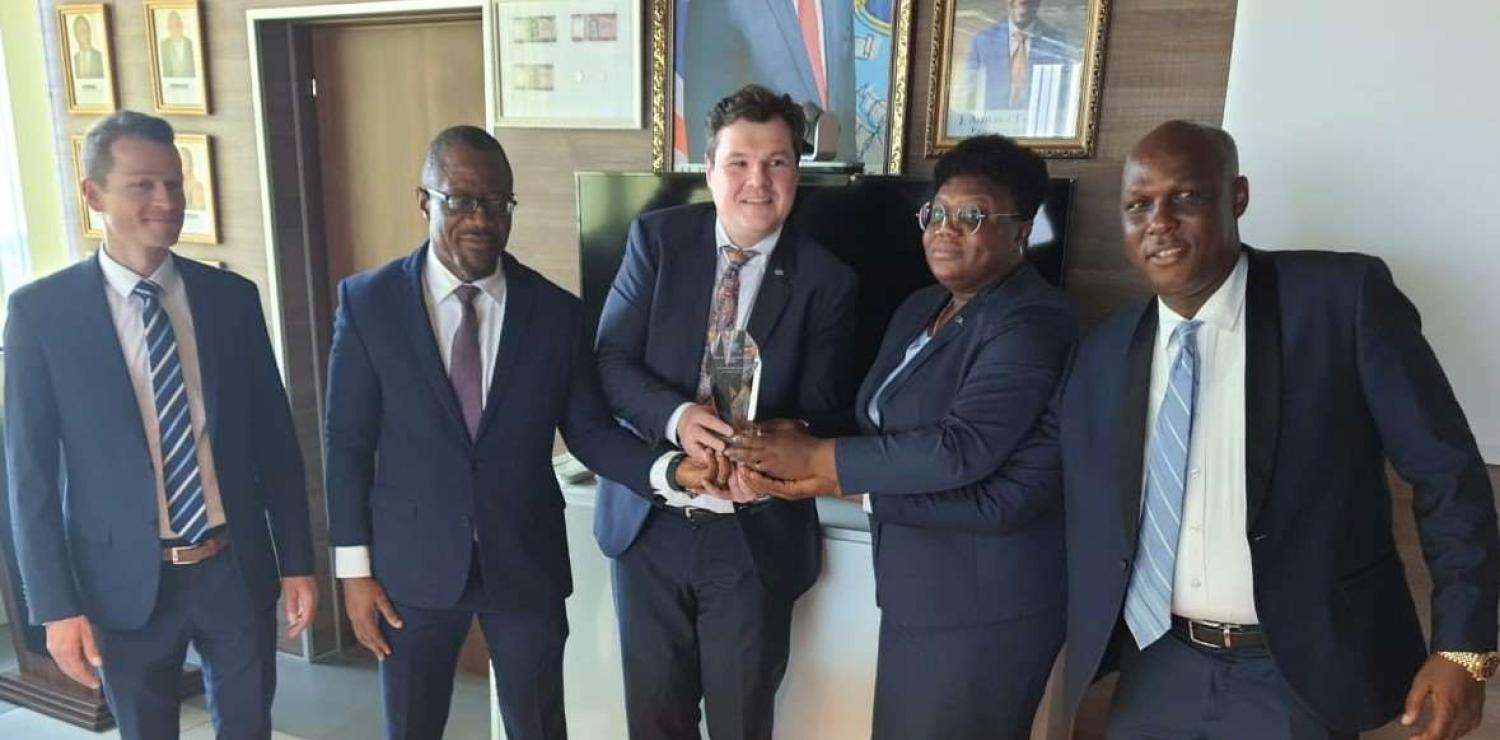 CBL Executive Governor J. Aloysius Tarlue, Jr. (second from left) receives the award from Messrs. Ulrich Rebele, Regional Sales Director of G+D and Alexander Huber, Product Manager for Security Threads of G +D.